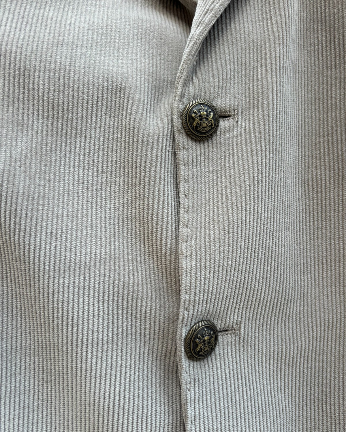 Primo piano dei bottoni decorativi della giacca monopetto Bharnaba Lamitam in velluto a coste beige, stile raffinato per l'inverno uomo.