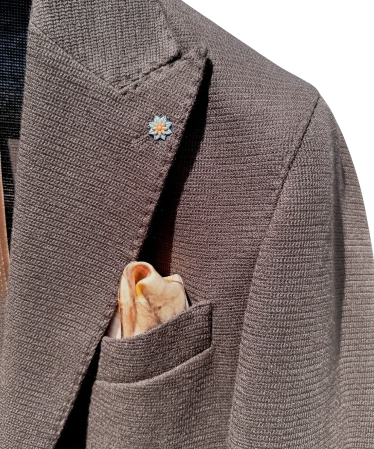 Dettaglio della giacca uomo monopetto Toyota con fiore decorativo sul revers e pochette beige, perfetta per uno stile moderno e sofisticato.