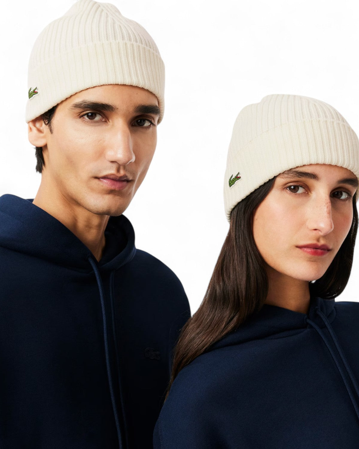Coppia indossa berretto lana spazzolata Lacoste bianco con logo ricamato, stile casual invernale per uomo e donna.