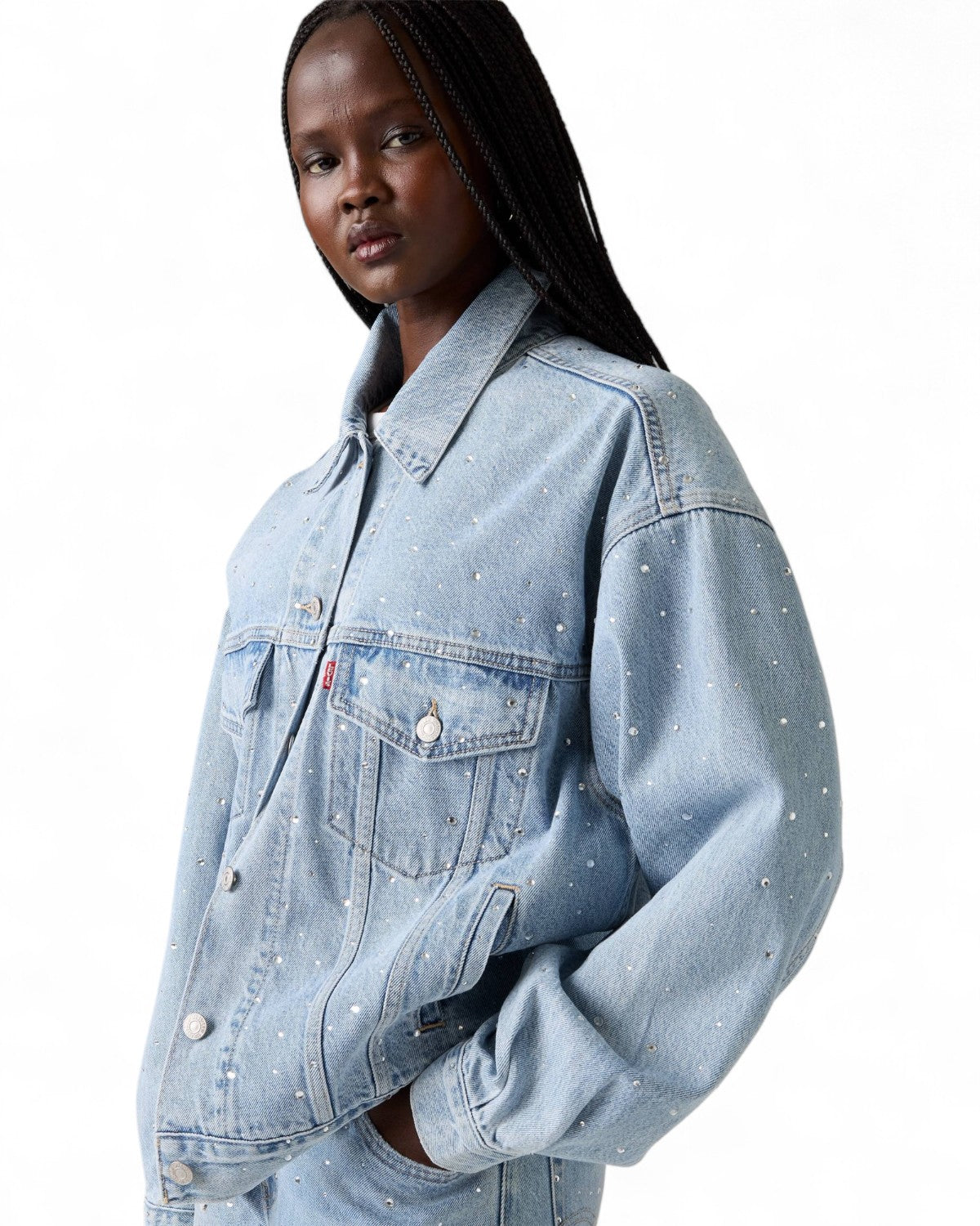 Vista laterale del Giubbino Jeans Trucker Strass di Levi's indossato, evidenzia la vestibilità ampia e i dettagli in strass sulle maniche.
