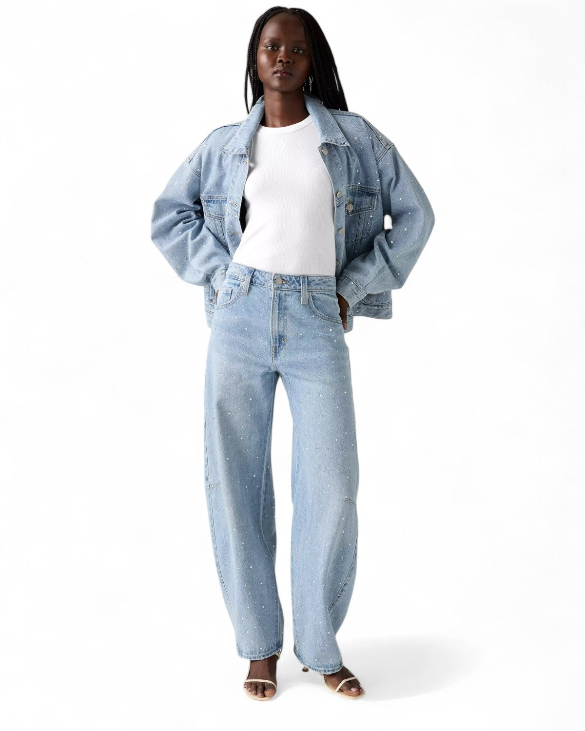 Modella indossa Jeans Baggy Barrel Levi's a Vita Media con giacca coordinata, fit comodo e design con strass per outfit invernale donna FW26.