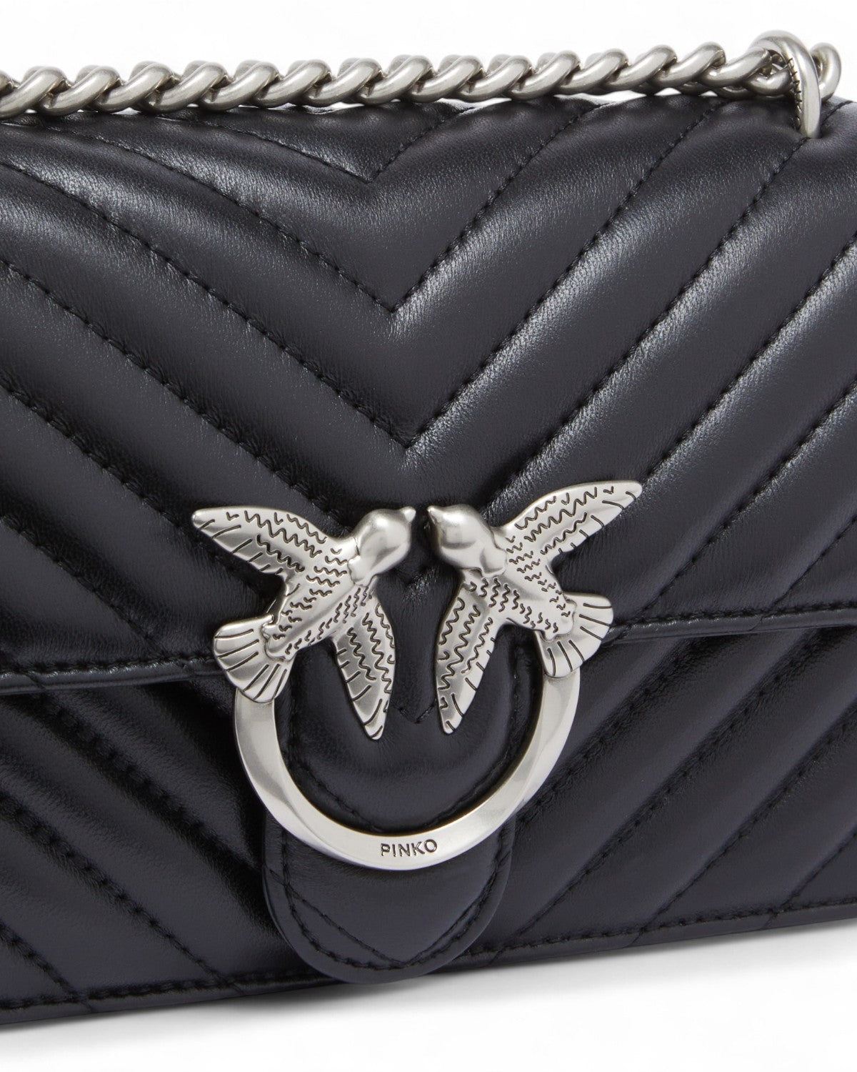 Dettaglio della fibbia Love Birds in metallo sulla Mini Love Bag Chevron in nappa trapuntata, simbolo iconico e raffinato del brand Pinko.