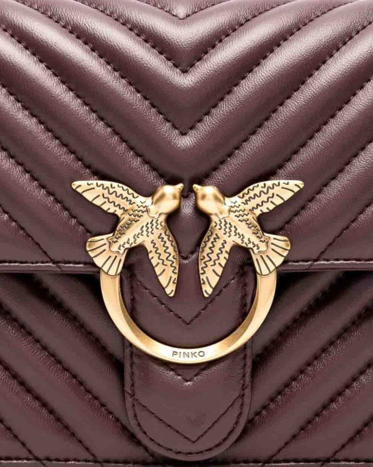 Dettaglio della fibbia Love Birds dorata sulla Love Bag Pinko in nappa matelassé chevron. Iconico elemento decorativo del brand.