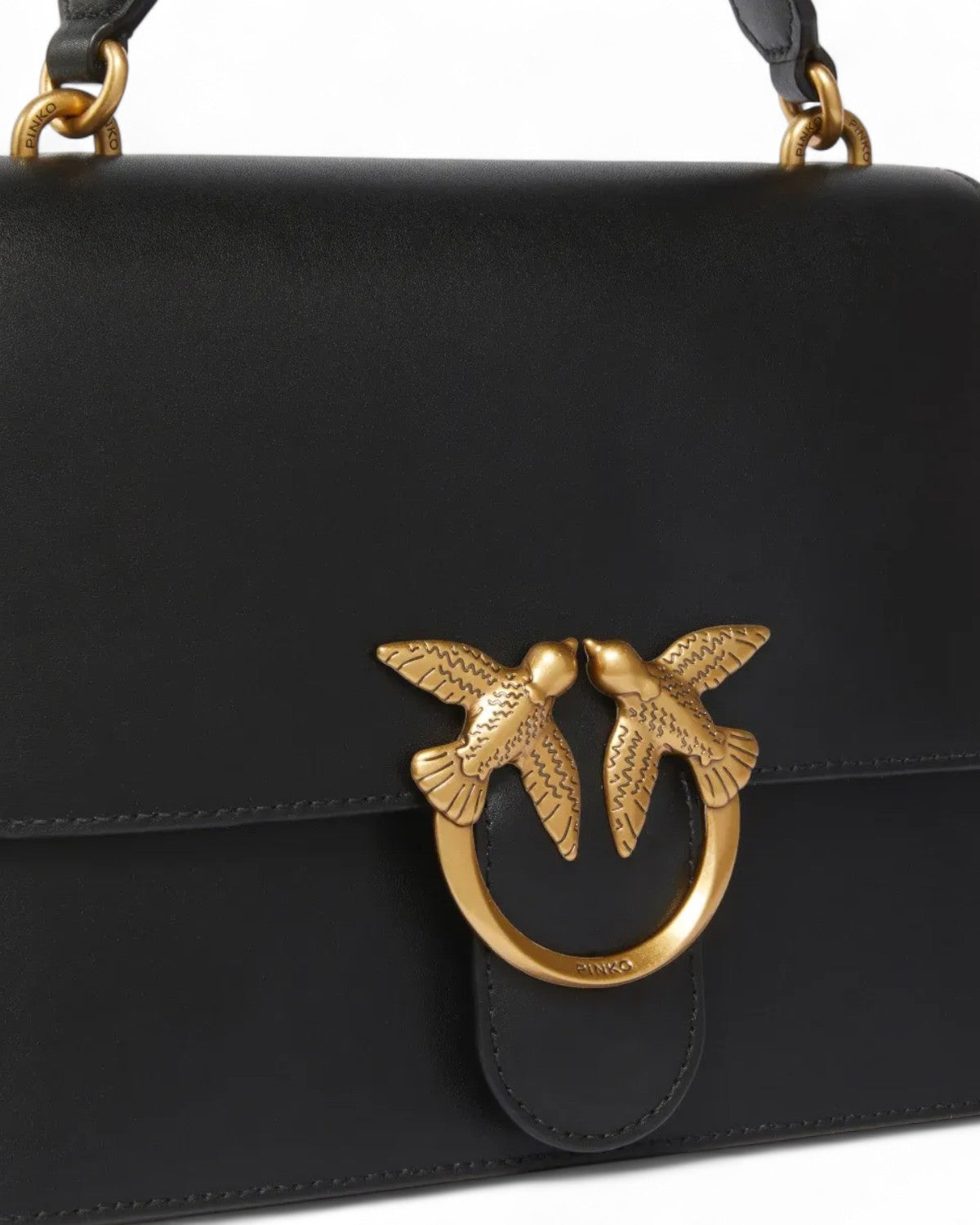 Dettaglio della chiusura dorata a forma di rondini sulla borsa Pinko Classic Love Bag Mini in pelle nera, simbolo iconico del brand.