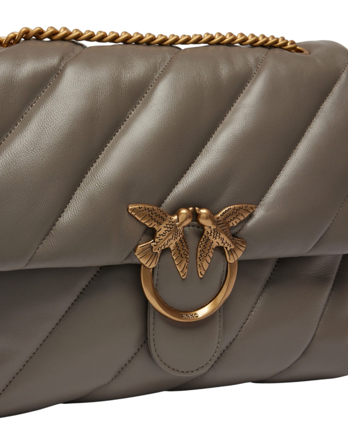 Primo piano della fibbia Love Birds dorata sulla borsa Big Love Bag Puff Maxi di Pinko, simbolo iconico di eleganza femminile.