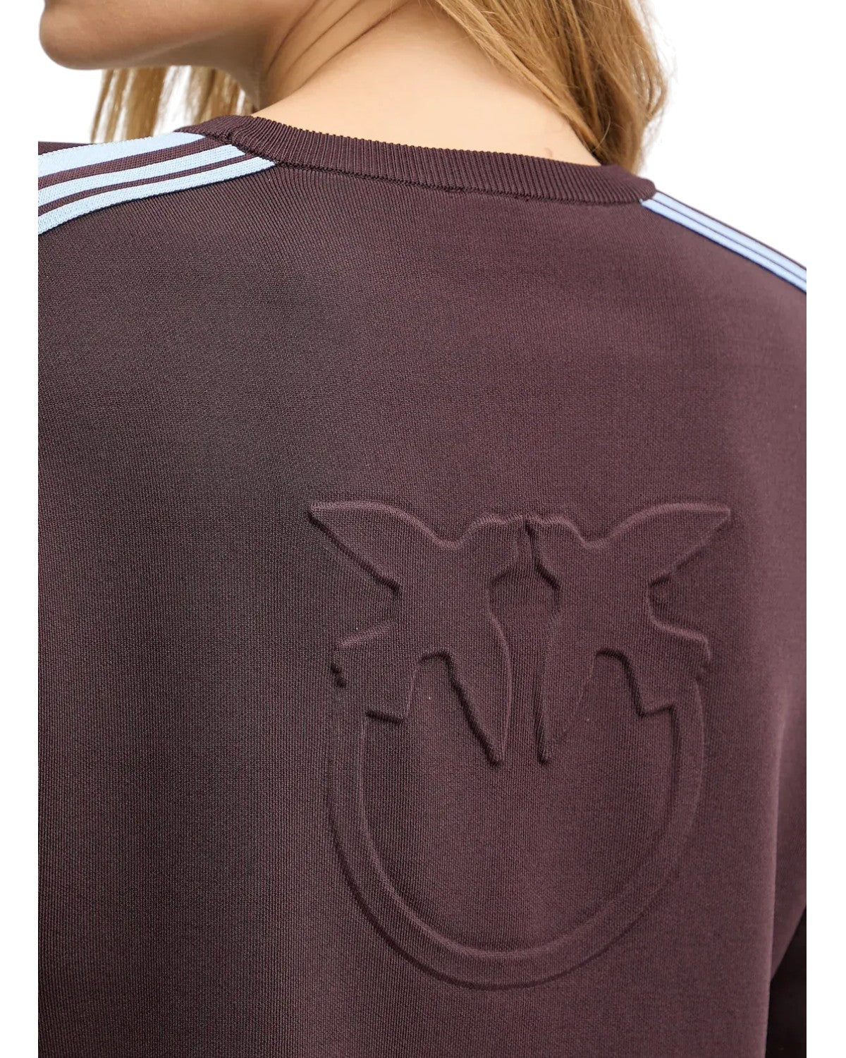 Particolare del logo Pinko in rilievo sul retro della felpa elasticizzata vinaccia, con dettagli sportivi sulle spalle.