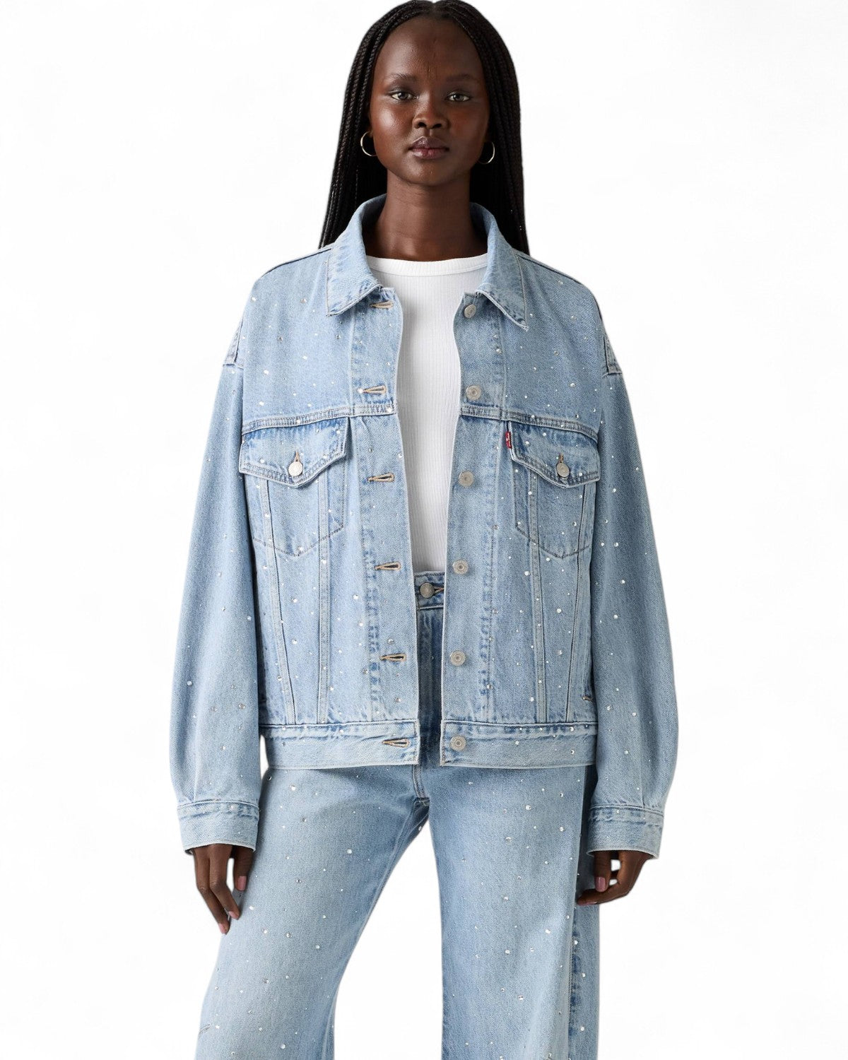 Modella indossa il Giubbino Jeans Trucker Strass di Levi's, stile rétro anni '90 con taglio oversize e strass su tutta la superficie.
