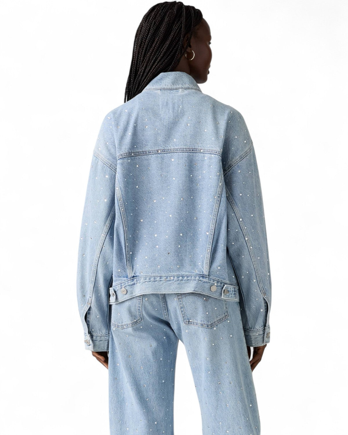 Retro del Giubbino Jeans Trucker Strass di Levi's indossato da una modella, con strass decorativi e regolatori laterali in vita.